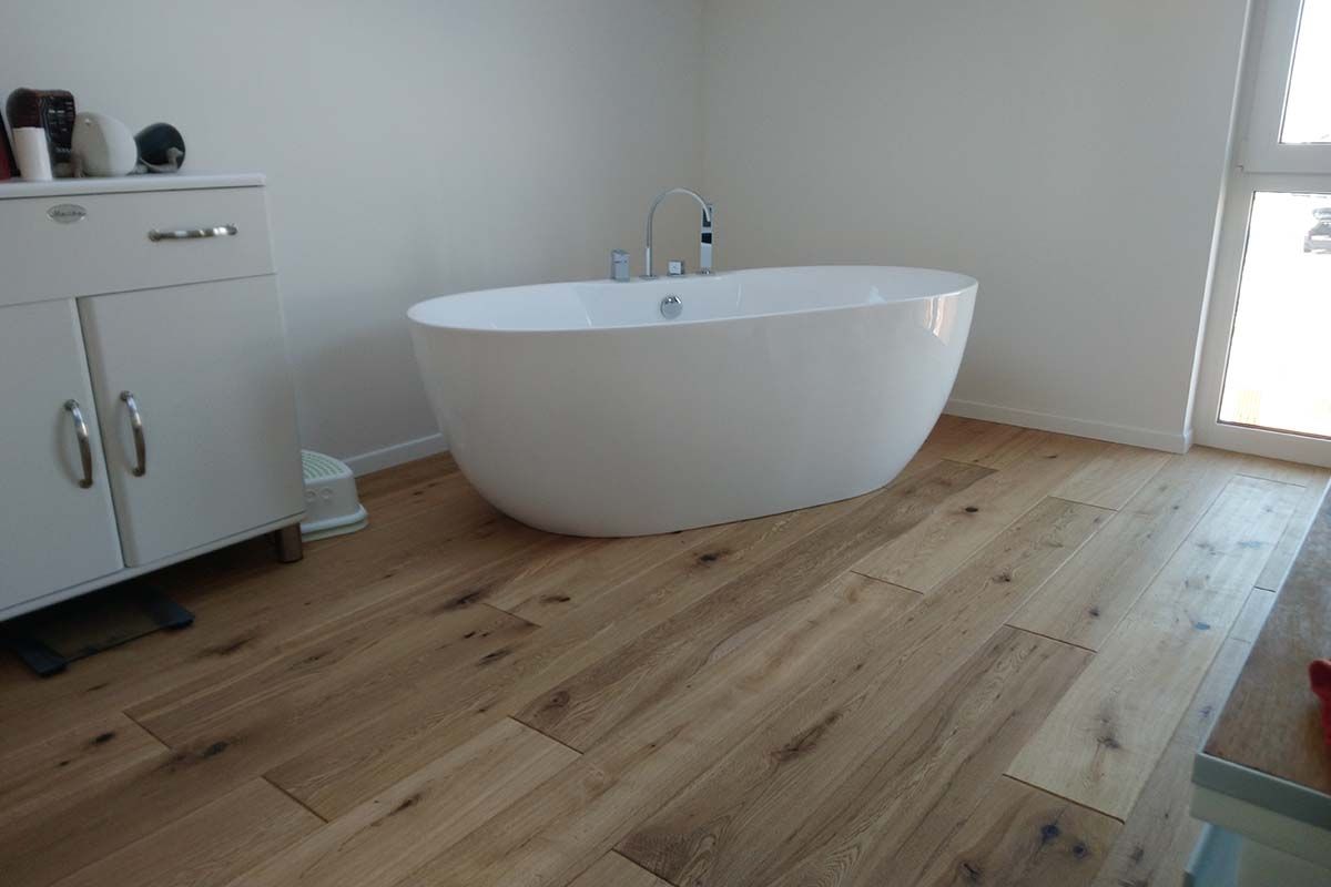 Badezimmer mit Parkettfußboden und Badewanne